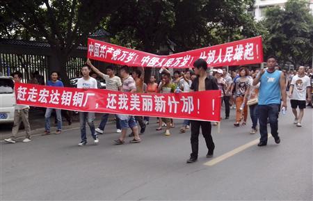 Local residents march with banners during a protest along a street in Shifang, Sichuan province 